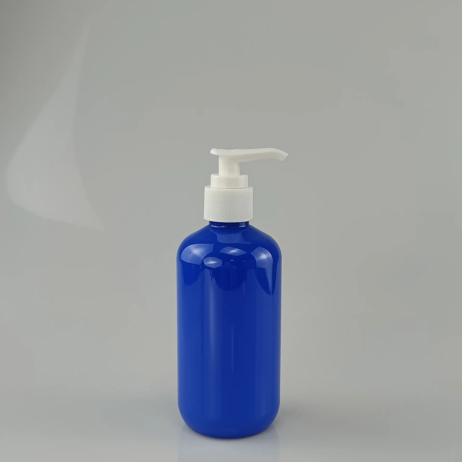 Cobalt blue cylindrical plastic bottle with custom logo, ideal for shampoo and body wash storage