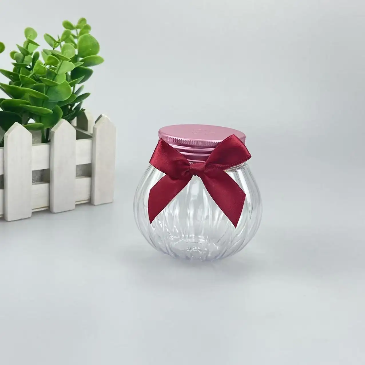 Custom 150ml food grade PET pumpkin shaped plastic jar with pink lid and red bow for candy and aromatherapy packaging