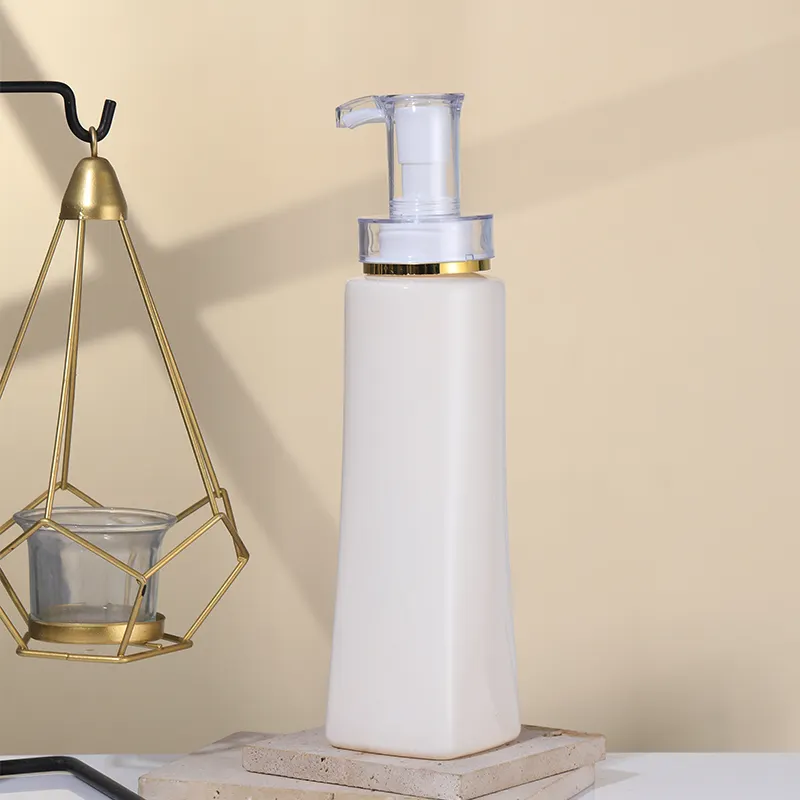 Matte off-white trapezoidal square PET foam pump bottle with transparent gold rim foaming pump, empty cosmetic mousse facial cleanser container, plain white background product photo